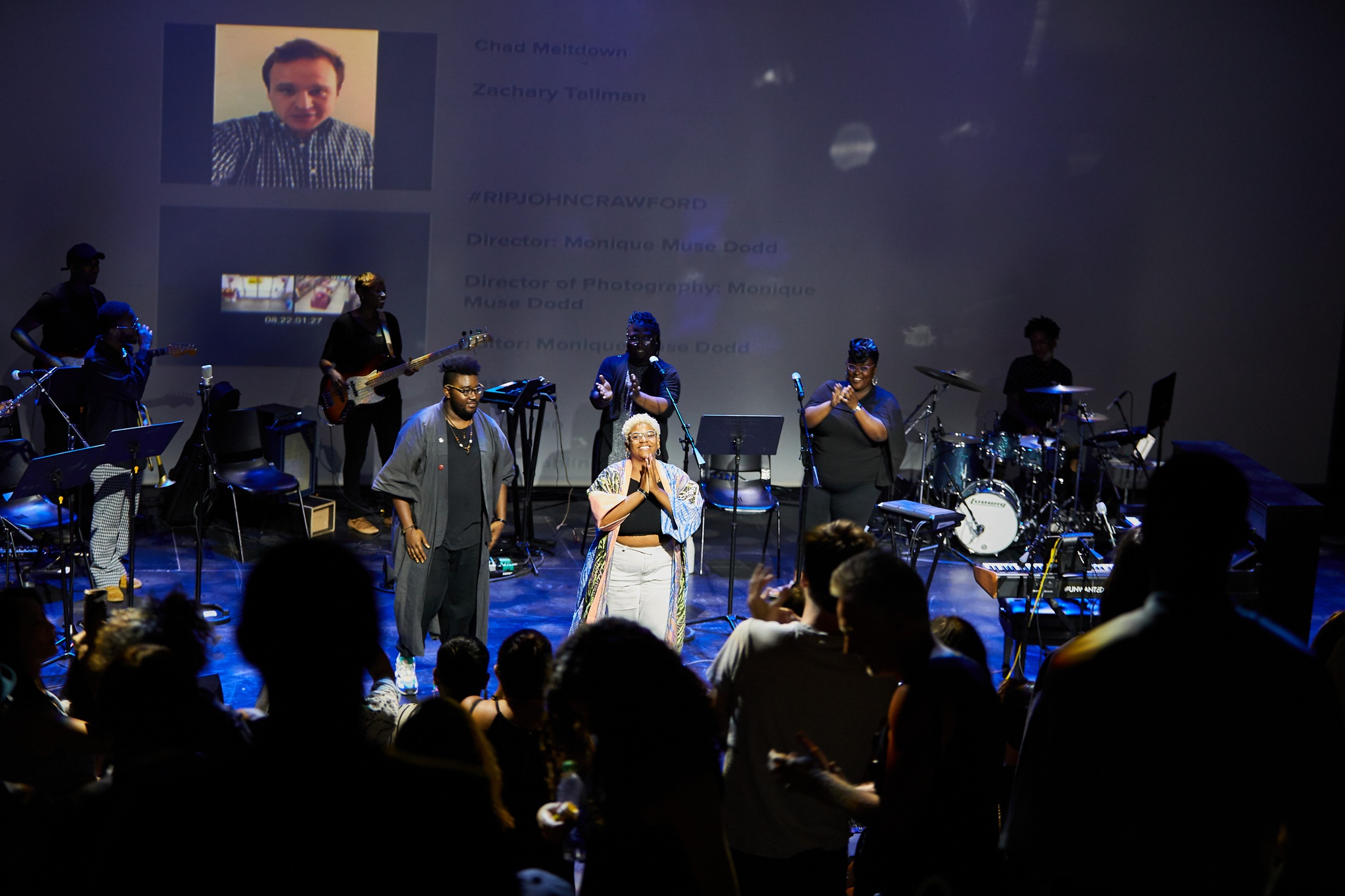 Performers taking a bow on stage to standing ovation.