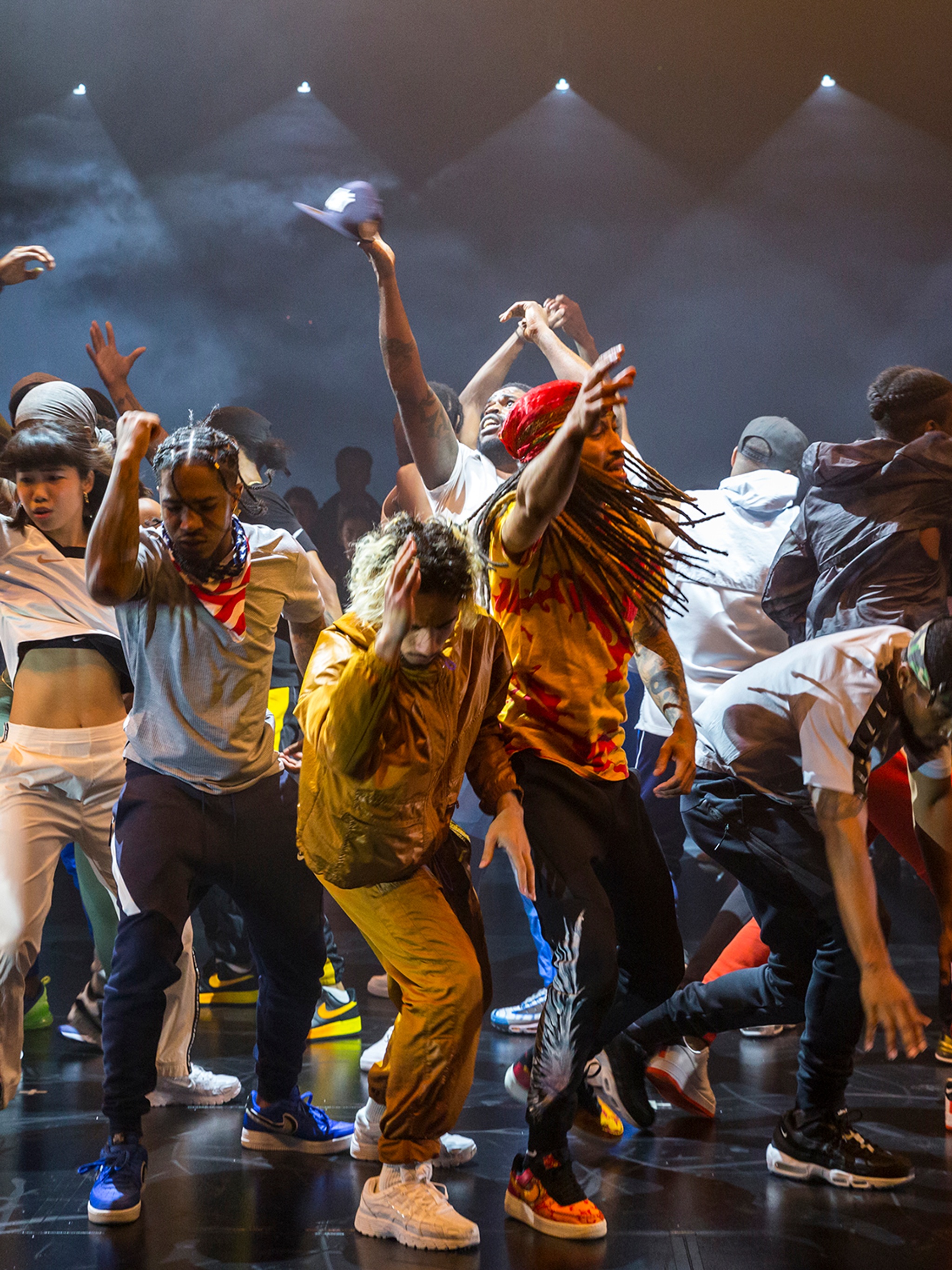 Maze dancers gathered together dancing in the middle of a black box theater