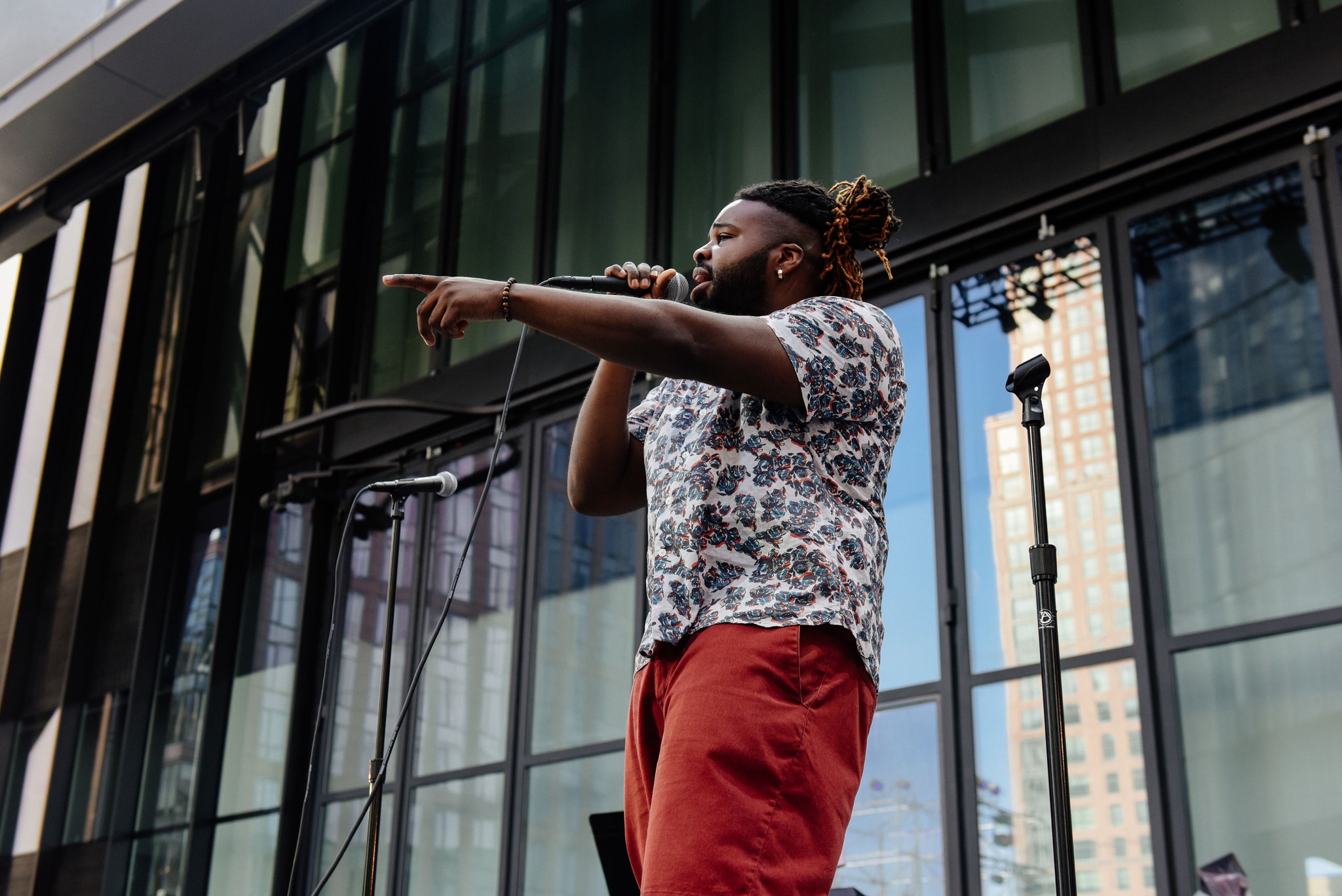 Singer singing on outdoor stage.