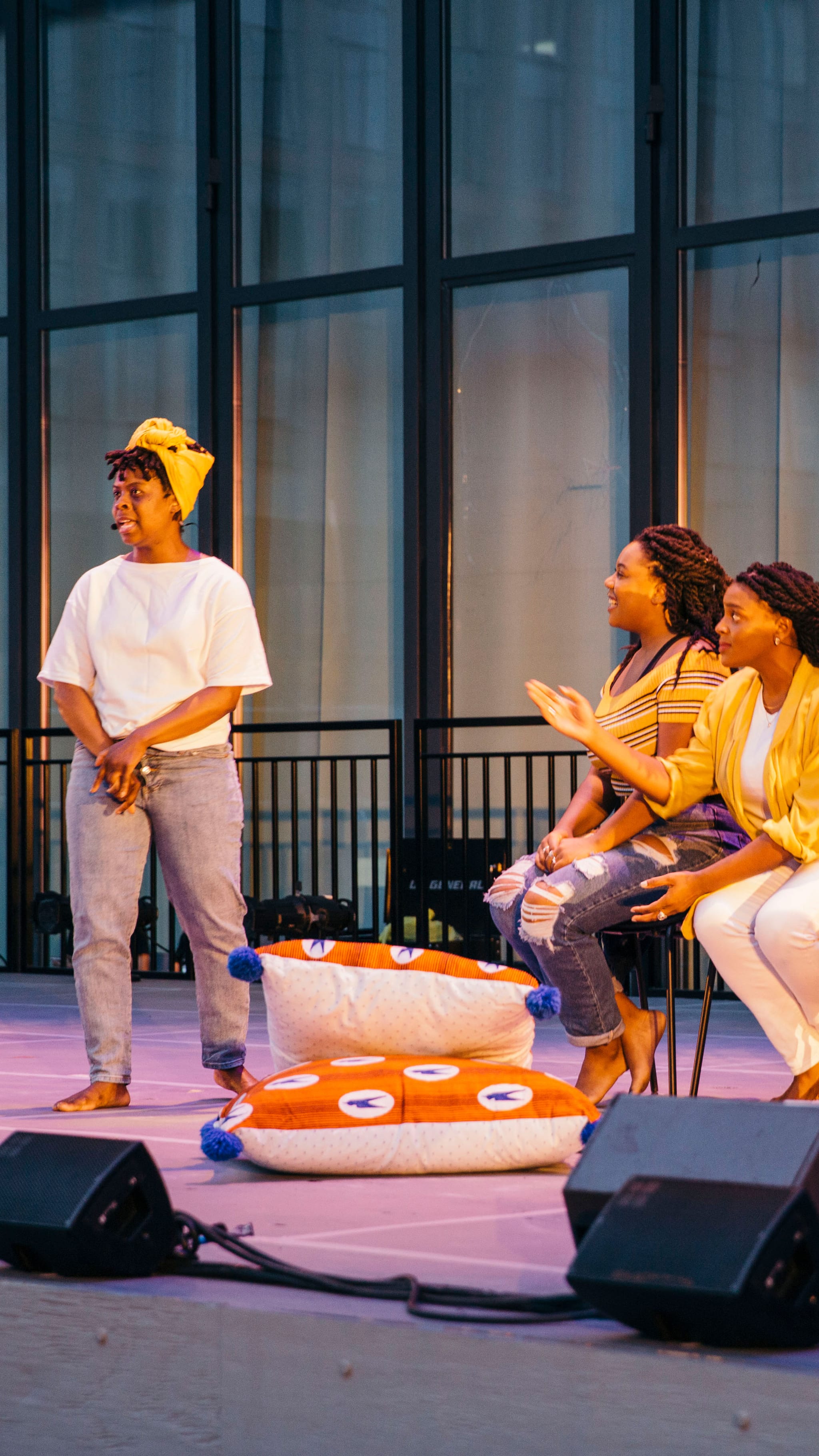 Three women acting on stage barefoot.