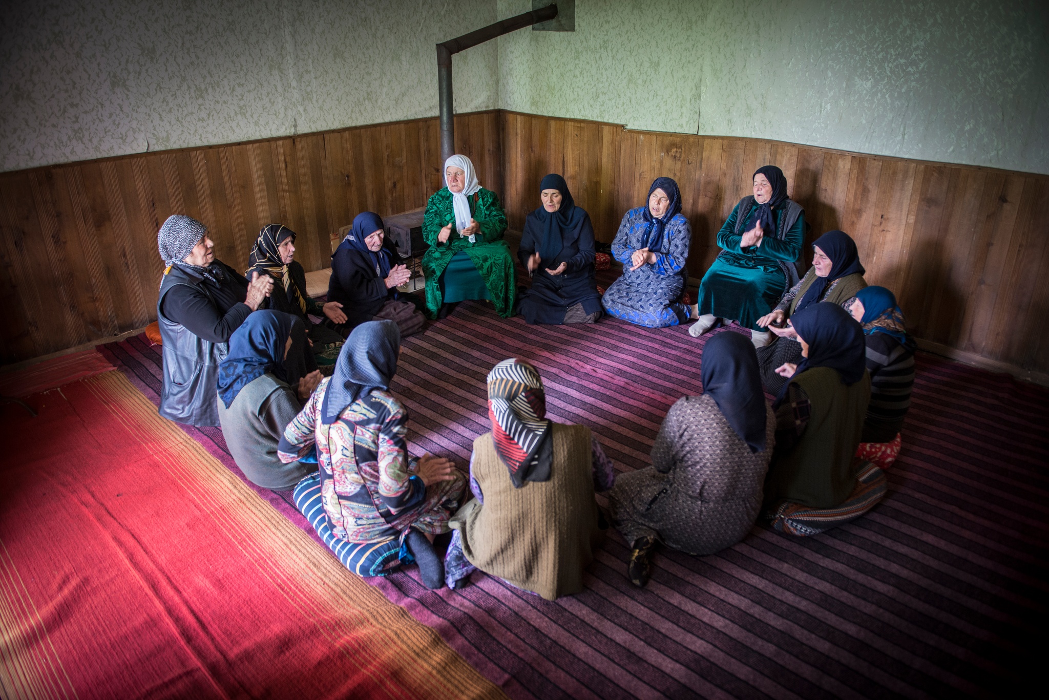 A group of women seated on a rug in a circle