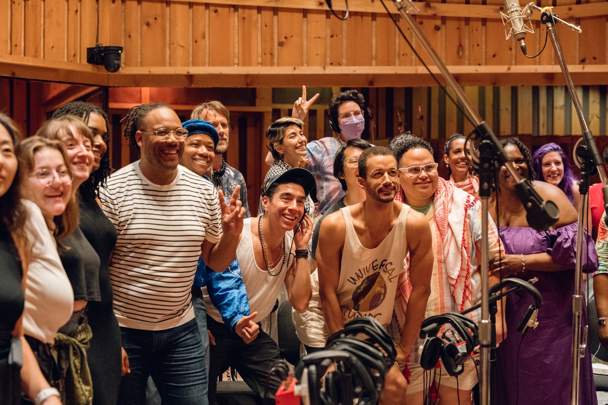 Troy poses with the choir after the recording session. They are all smiling, holding up peace signs, and celebrating their work. 