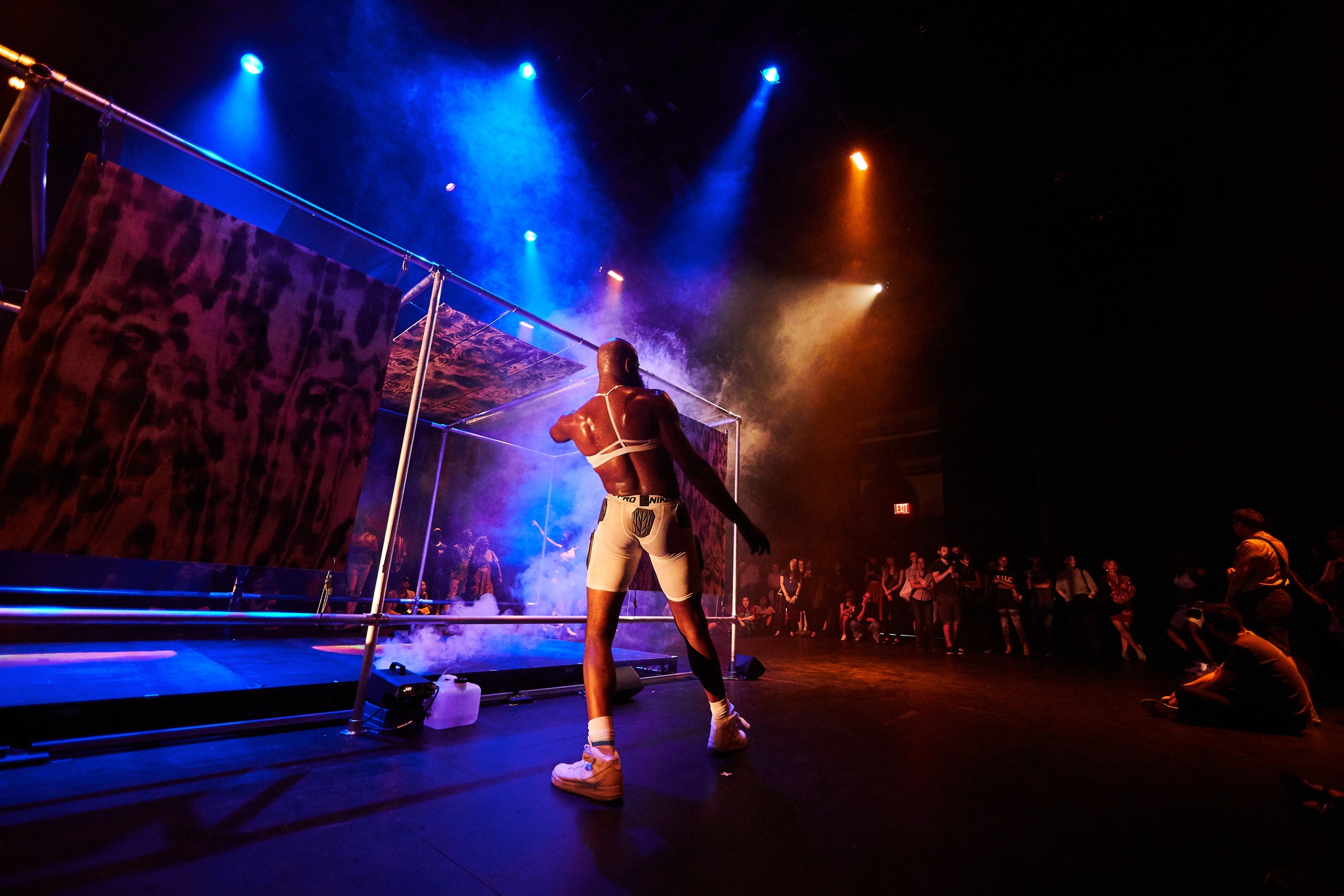 Dancers on a dramatically lit stage in front of a crowd.