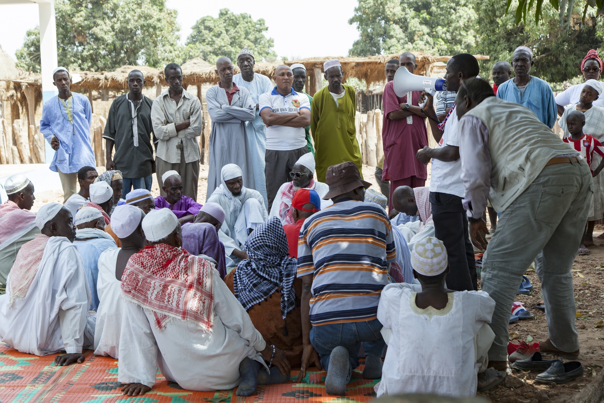 A group of men gathered around a speaker with a bullhorn