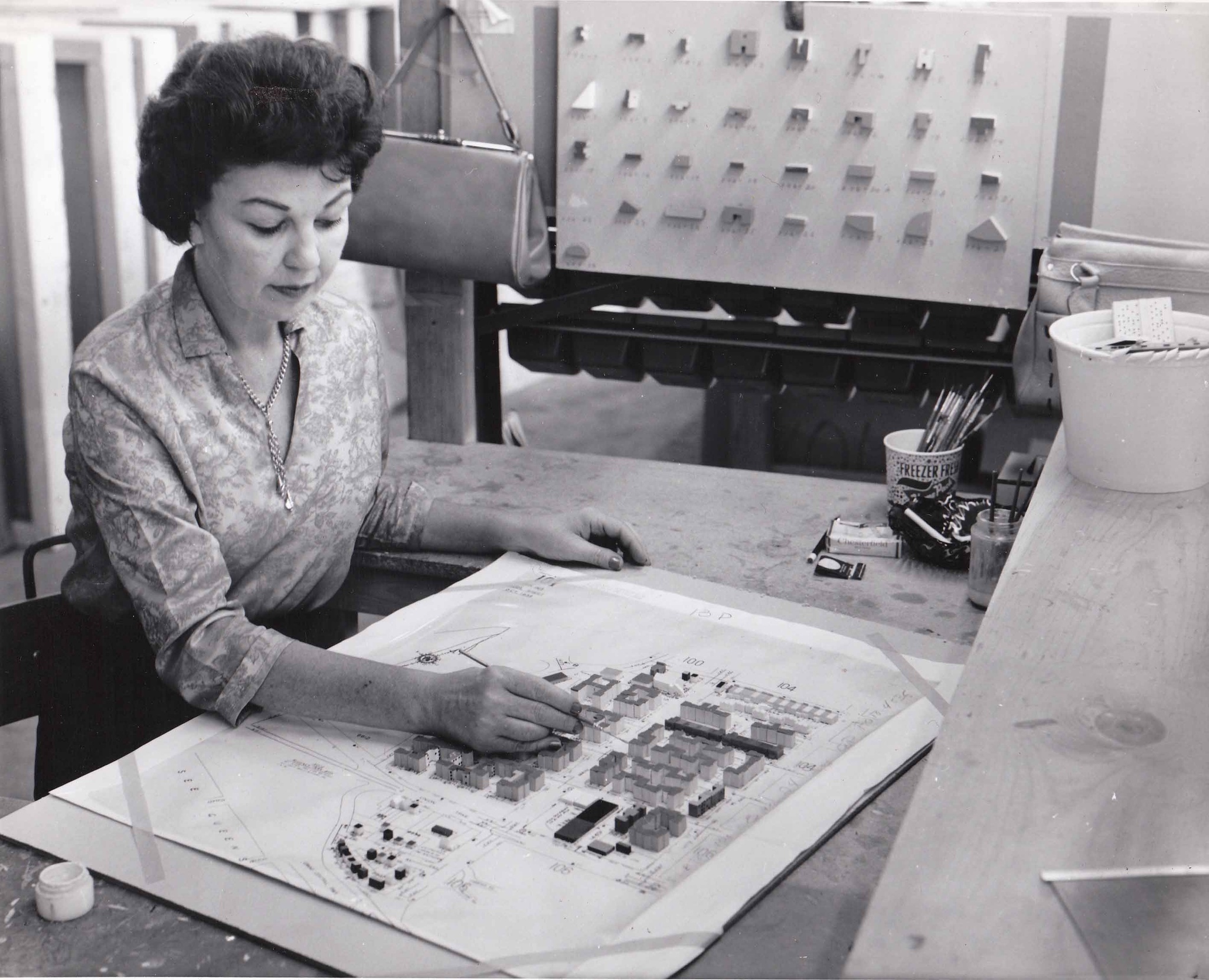 A woman paints tiny model buildings during the construction of the Panorama of the City of New York