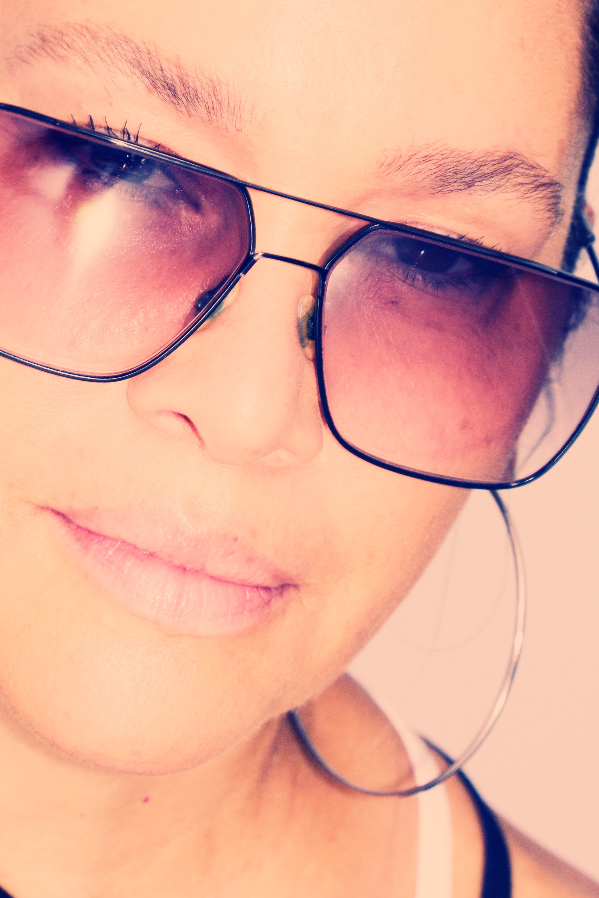 A close-up photo of Jocelyn Cooper, who wears sunglasses and a hoop earring. 