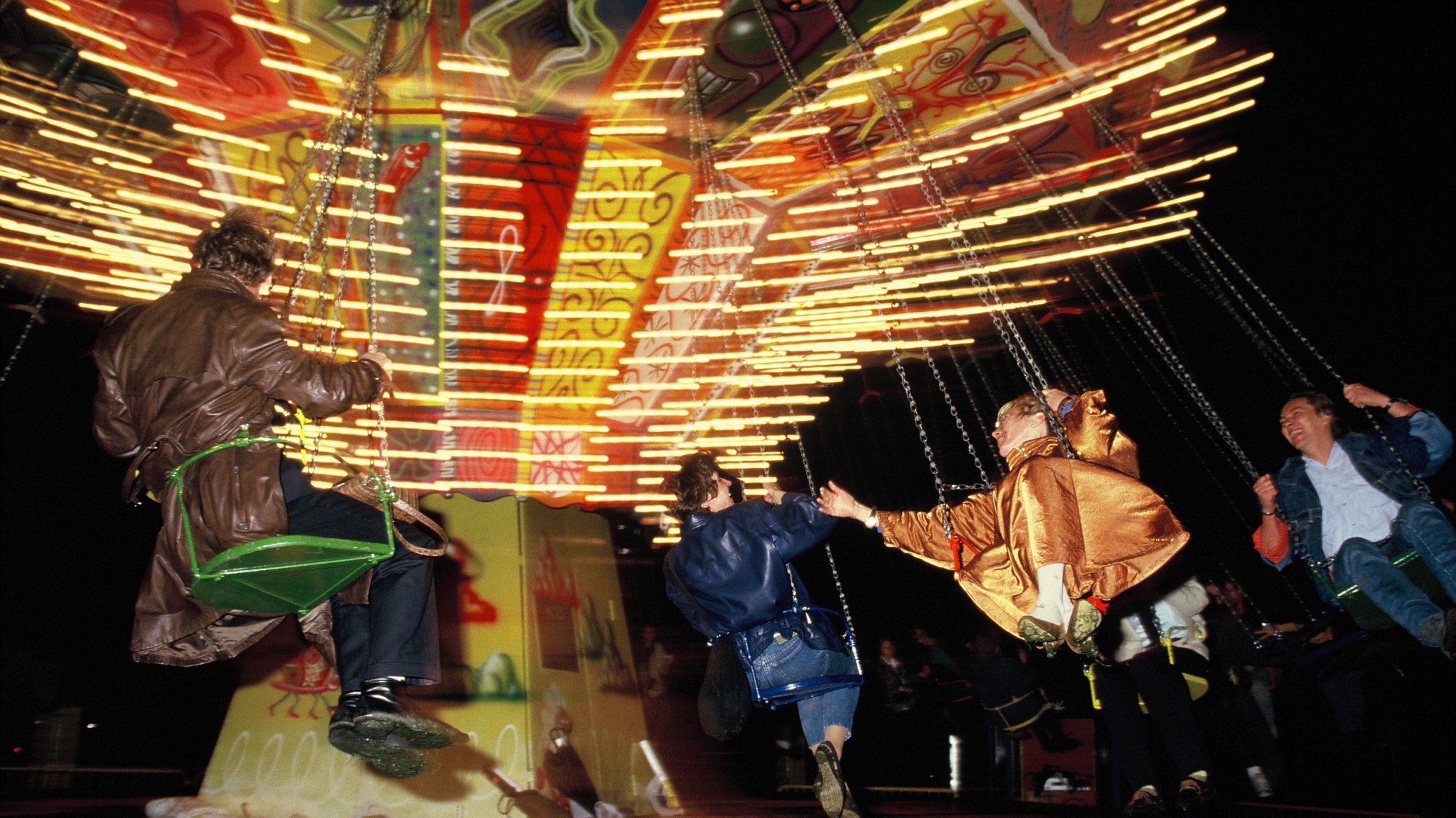 A chair swing ride painted by artist Kenny Scharf spins riders around on their suspended chairs. 