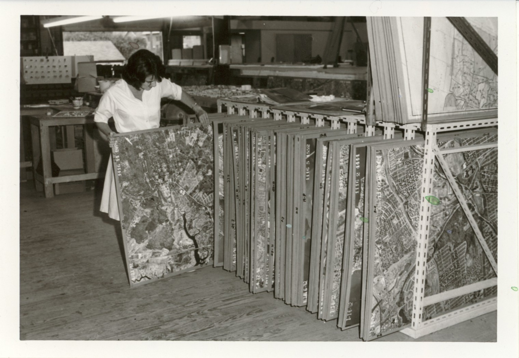 A woman pulls out a panel of the Panorama of the City of New York from storage